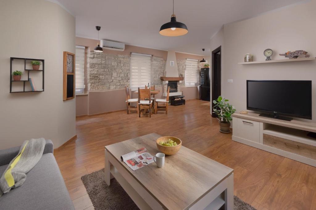 a living room with a couch and a tv and a table at Vecchio mercato Pula Apartman in Pula