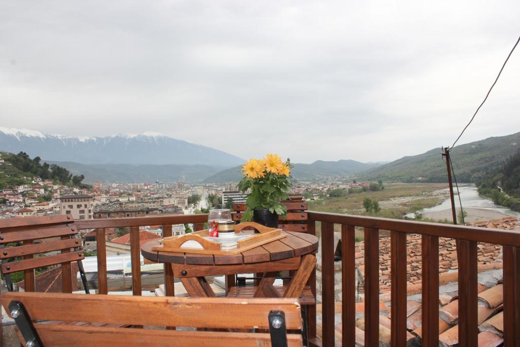 a table on a balcony with a view of a city at Guesthouse Arjan in Berat
