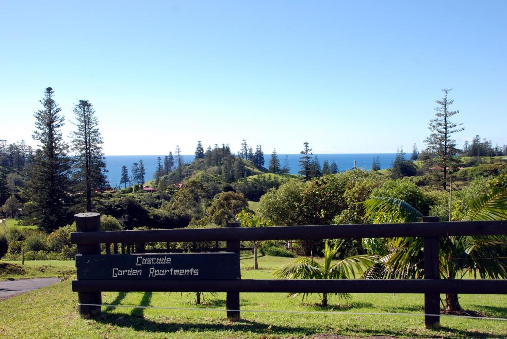 a bench in a park with the ocean in the background at Cascade Garden Apartments in Burnt Pine