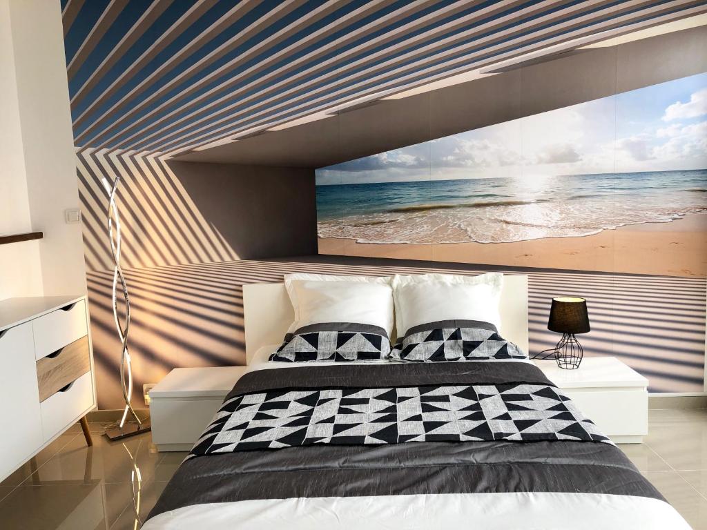 a bedroom with a large painting of the beach at Barcaresa-RAVISSANT APPARTEMENT PISCINE VUE MER WIFI PARKING GRATUIT in Le Barcarès