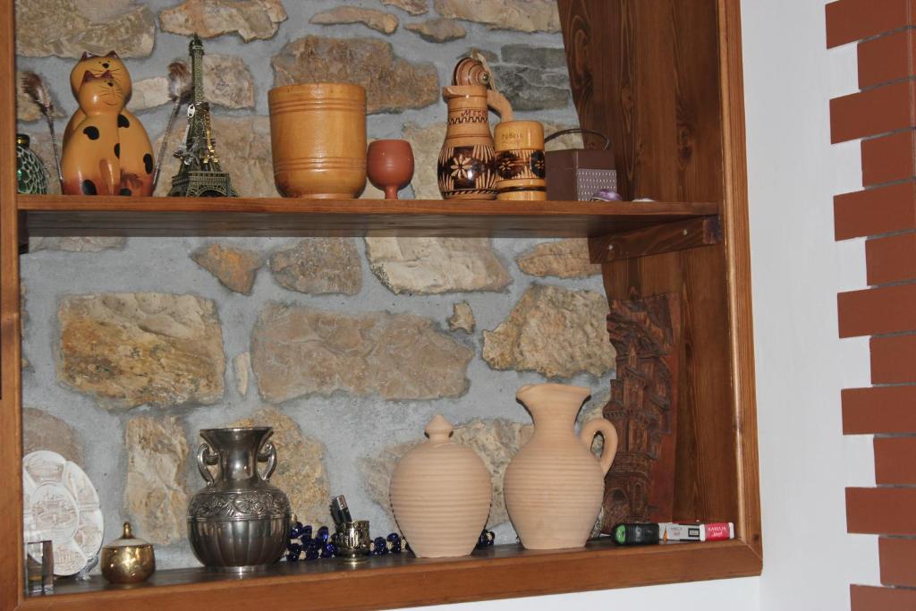 a shelf with vases and other items on it at Guesthouse Arjan in Berat