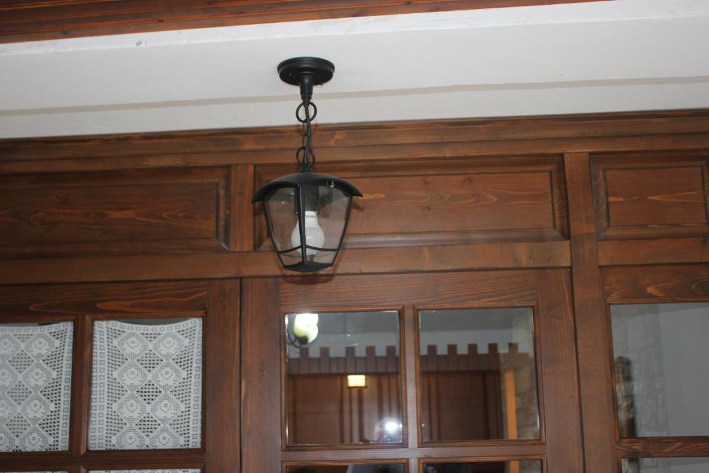 a light fixture hanging over a wooden door at Guesthouse Arjan in Berat
