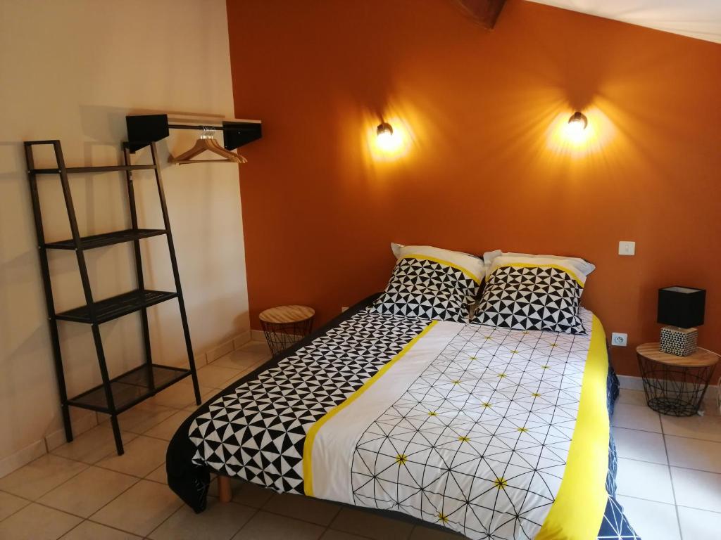 1 dormitorio con cama y pared de color naranja en Le Domaine Leylandy, en Saint-Sulpice-de-Royan