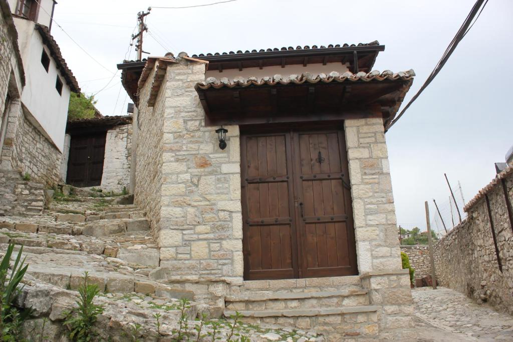 a small stone house with a wooden door at Guesthouse Arjan in Berat