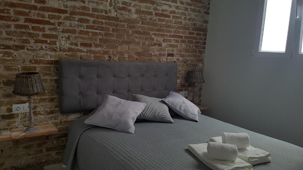 1 dormitorio con 1 cama con pared de ladrillo en Luxury Apartment In Triana Close To The River en Sevilla