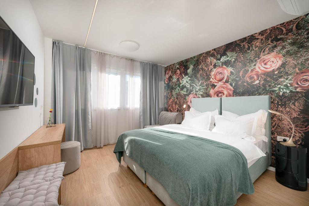 a bedroom with a bed with a floral wall at Skaline Luxury rooms Split in Split