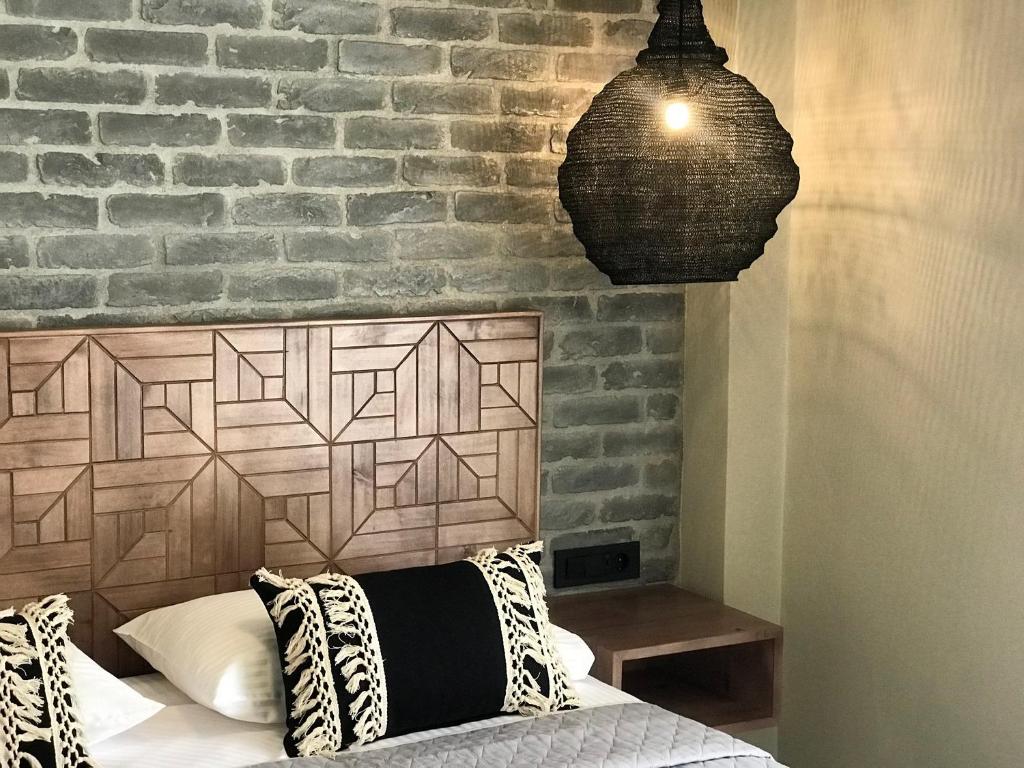 a bedroom with a bed with a brick wall at Oasis Apartments in Tolo