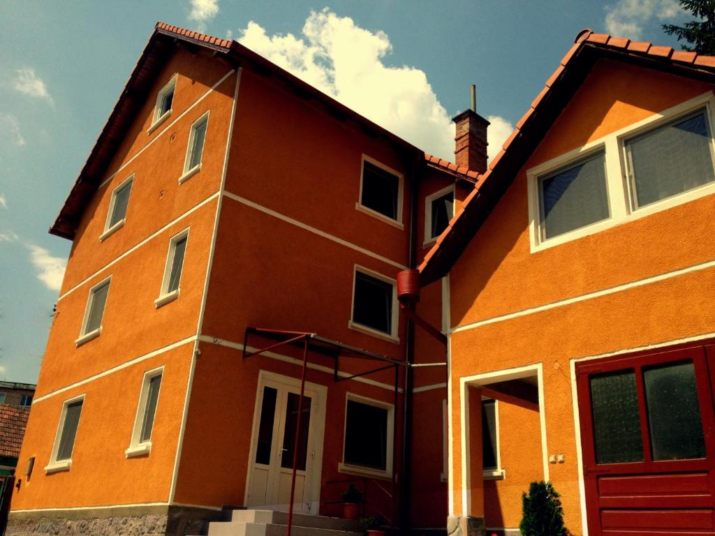 a large orange building with a red door at Pensiunea Bobo Panzio in Sfântu-Gheorghe