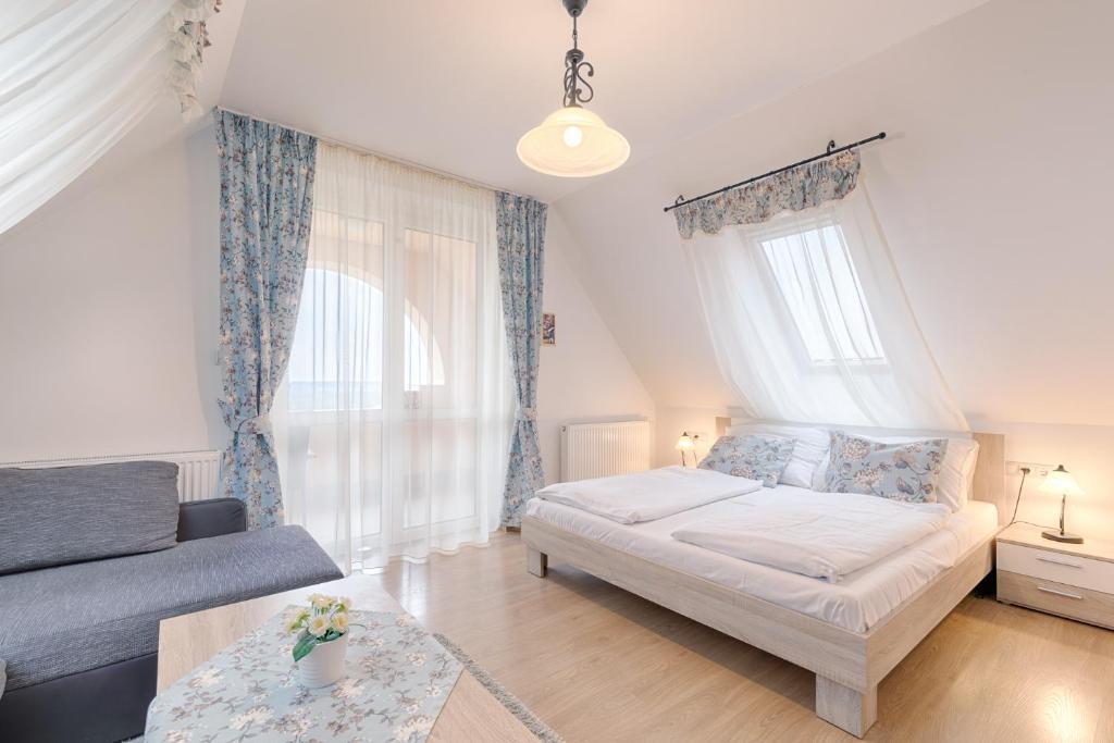 een kleine slaapkamer met een bed en een bank bij Fortuna 7 Apartments in Hévíz