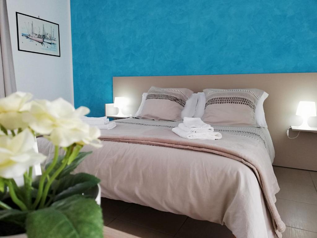 una camera con un letto con una parete blu di Appartamento Gambero Beach a Santa Teresa di Riva