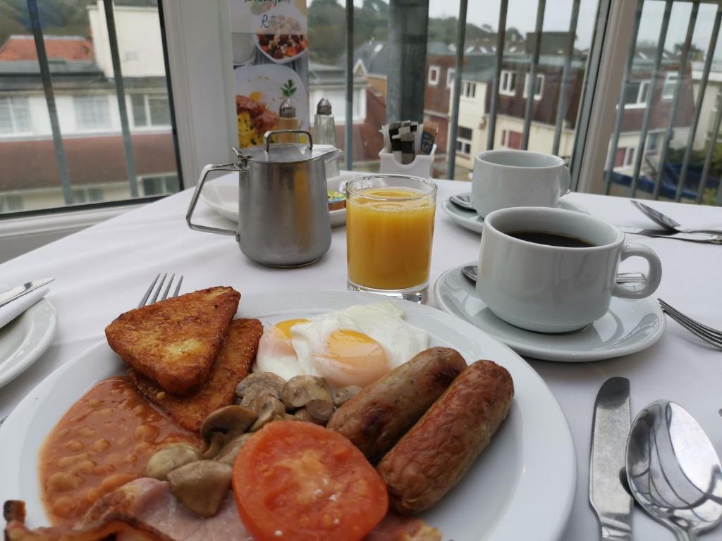 a plate of breakfast food with eggs sausage and toast at The Riviera Hotel & Apartments - Alum Chine in Bournemouth