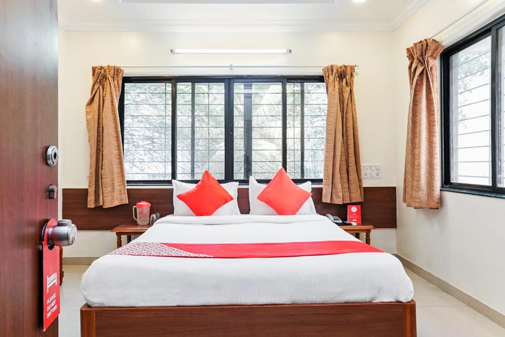 浦那的住宿－Hotel Rajdeep，一间卧室配有一张带红色枕头的大床