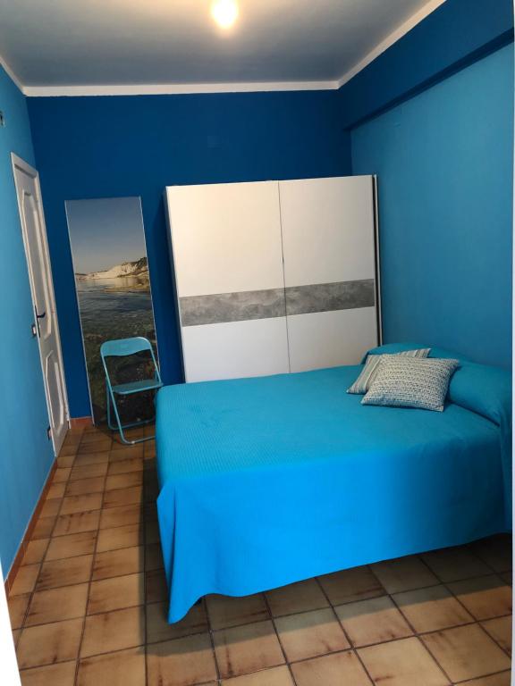 Dormitorio azul con cama y pared azul en A due passi dal mare, en Realmonte