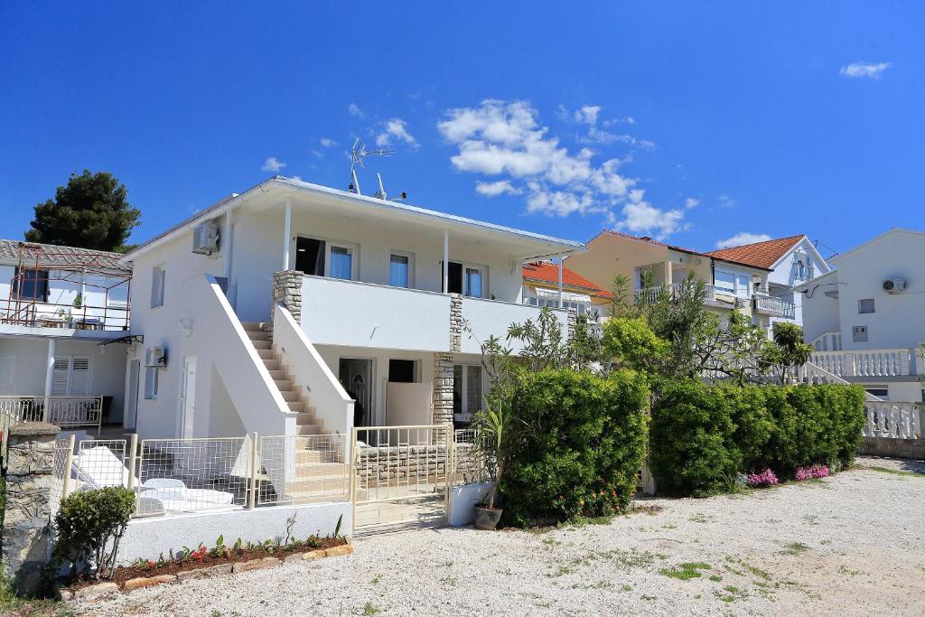 a white house with stairs and bushes at Apartments Brankica in Zadar