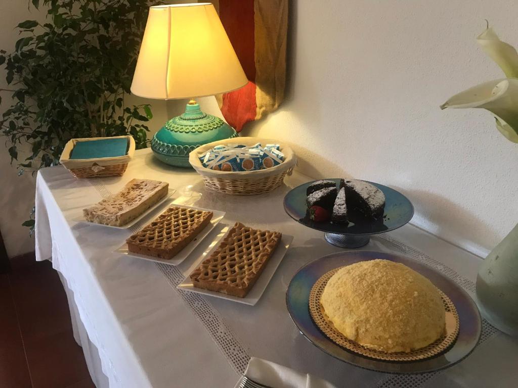 a table with a cake and other desserts on it at Hotel Spartivento in Chia