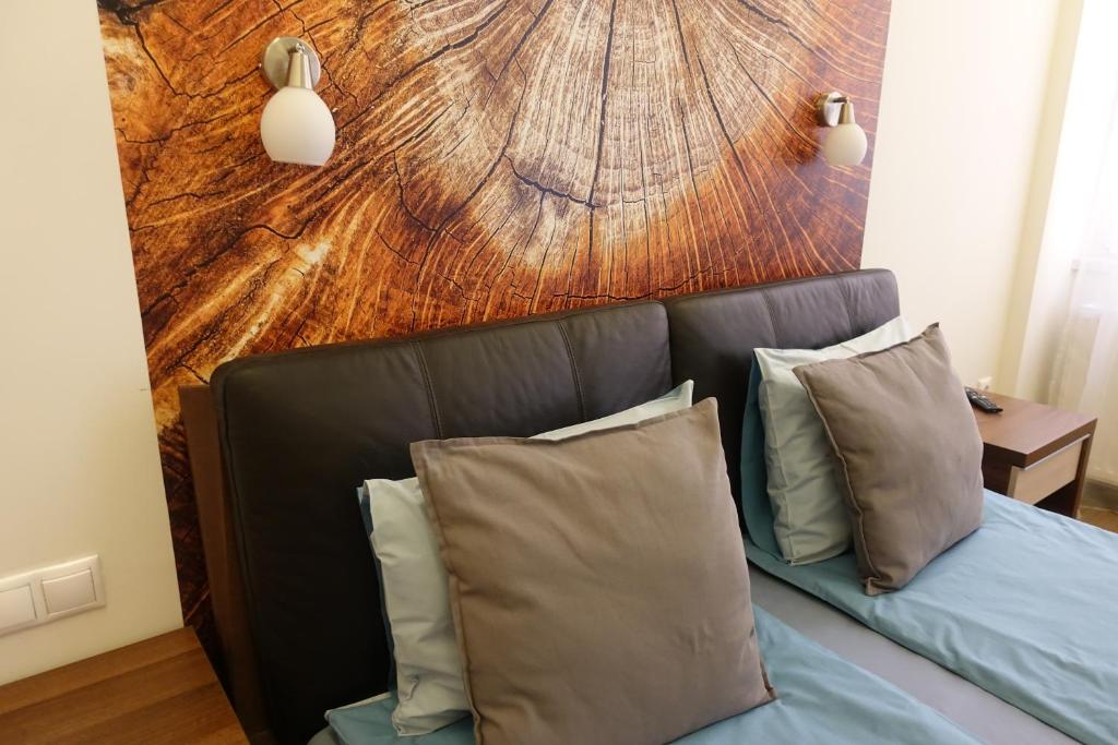 a bed with pillows in a room with a wooden wall at Frank & Fang Apartments MK7 in Budapest