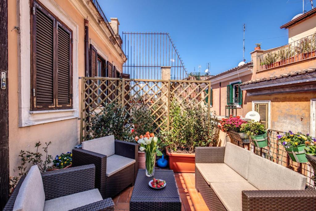 a balcony with furniture and flowers on a building at Palatino Terrace in Rome