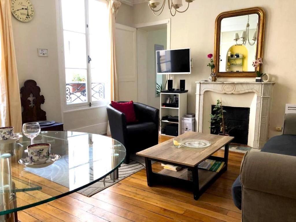 un salon avec une table basse et une cheminée dans l'établissement L'appartement Boulnois, à Paris