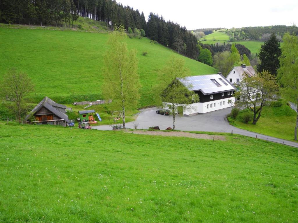 eine Luftansicht eines Hauses auf einem grünen Feld in der Unterkunft Ferienwohnung Schütte-Mühle in Schmallenberg