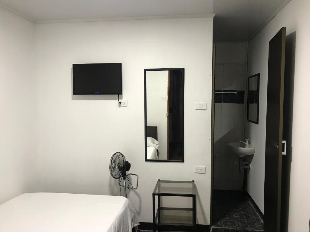 a bedroom with a bed and a mirror and a sink at Residencias la Marquesa 2 in Manizales