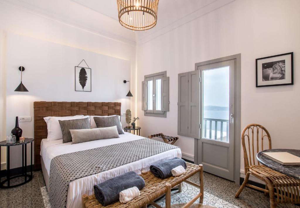 a bedroom with a bed and a table and a window at Amelot Art Suites in Fira