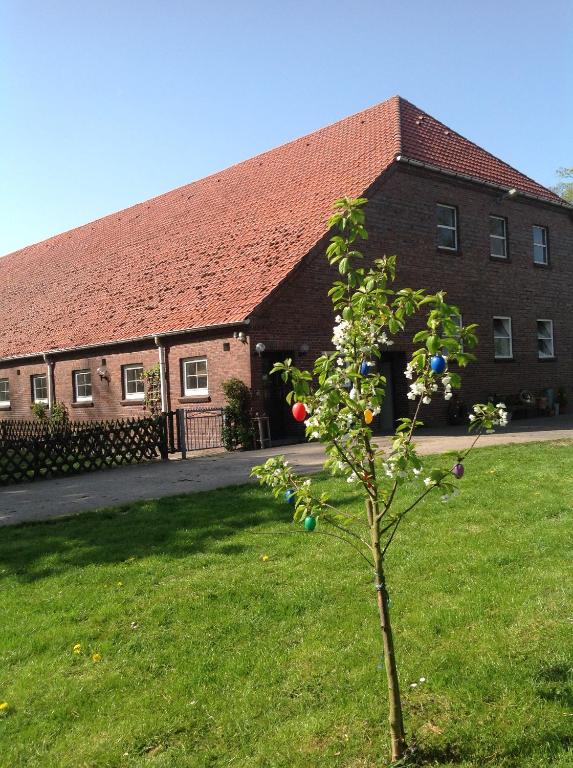 ein Haus mit einem Apfelbaum vor einem Gebäude in der Unterkunft Ferienwohnung Leschke in Nordenham