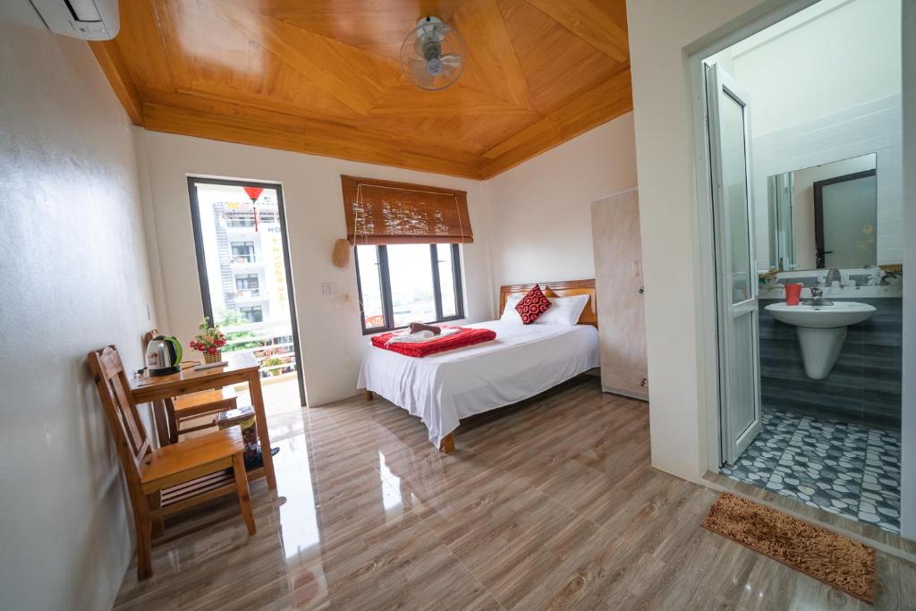 a bedroom with a bed and a bathroom with a sink at Phong Nha Homestay in Phong Nha