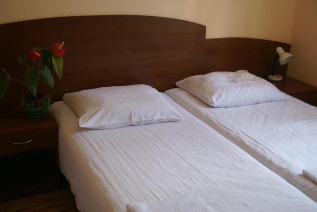 two beds with white sheets and pillows in a bedroom at Hotel Prokocim in Krakow