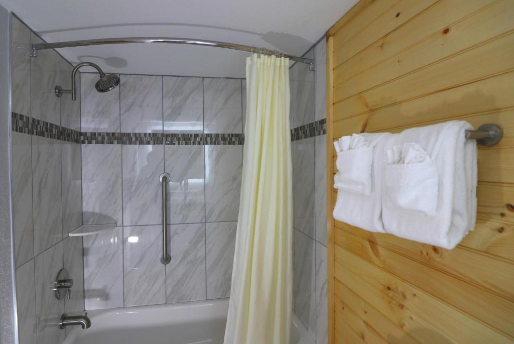 a bathroom with a shower with a shower curtain at Howard Johnson by Wyndham Downtown Gatlinburg in Gatlinburg