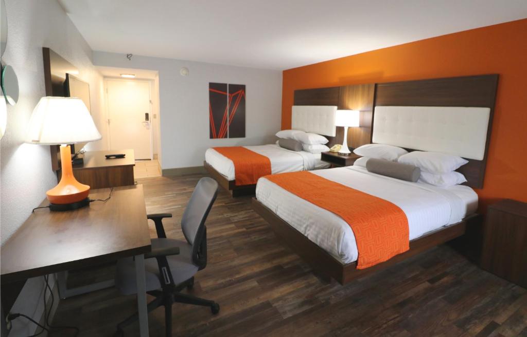 a hotel room with two beds and a desk at Howard Johnson by Wyndham Downtown Gatlinburg in Gatlinburg