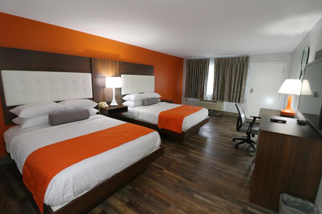 a hotel room with two beds and a desk at Howard Johnson by Wyndham Downtown Gatlinburg in Gatlinburg