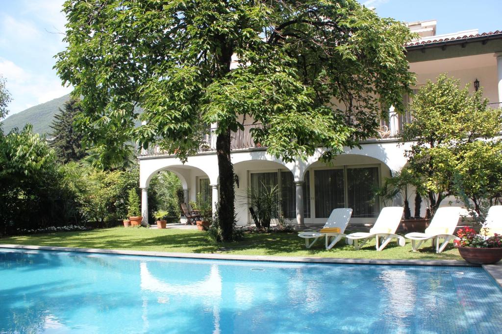 eine Villa mit einem Pool vor einem Haus in der Unterkunft Villa Olevano in Ascona