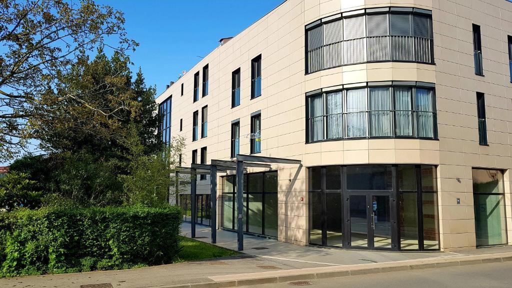 a large building with glass doors on a street at Apartman Leon in Umag