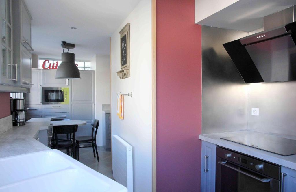 a kitchen with a pink wall and a table at Le Gite d&#39;Emilie in Entraygues-sur-Truyère