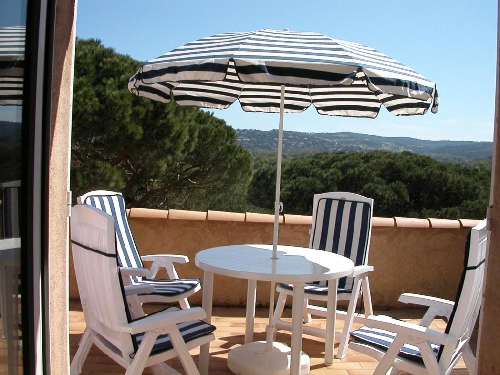 加桑的住宿－DOMAINE DE FONT MOURIER，阳台配有桌椅和遮阳伞