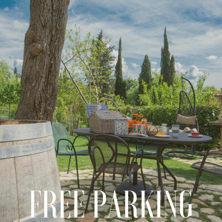 a table and chairs in a yard next to a tree at La Coroncina Lodging in Siena