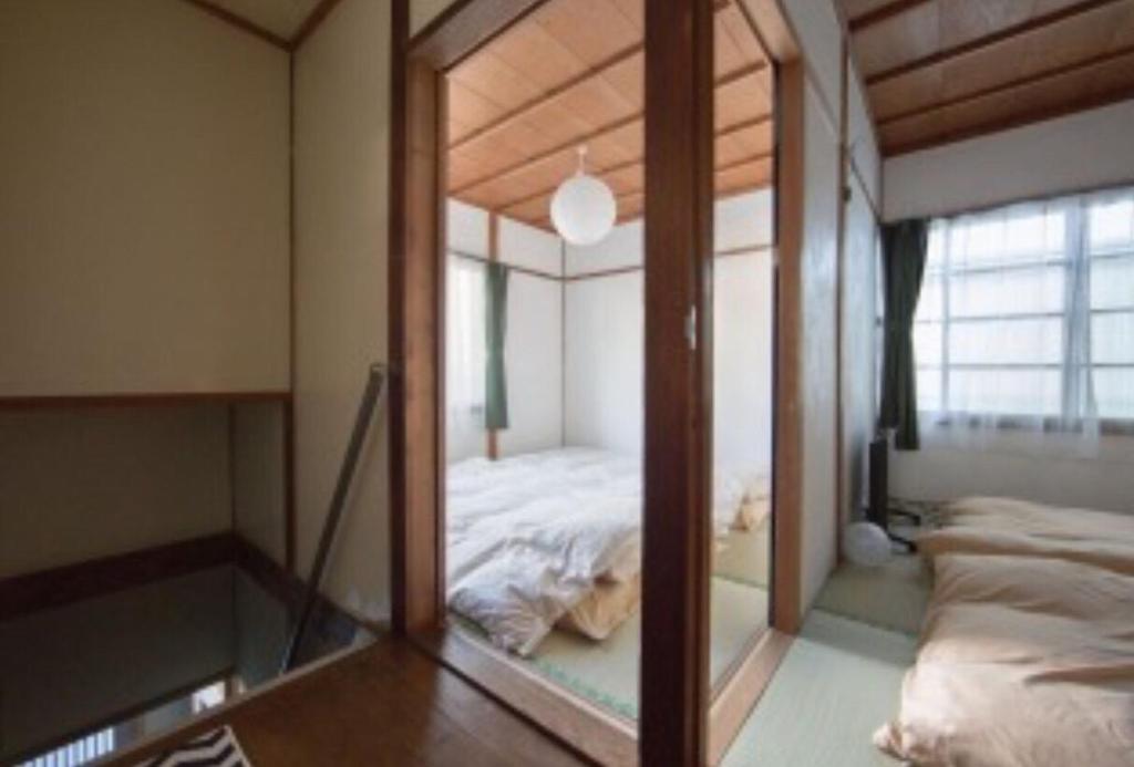 A bed or beds in a room at 昭和レトロタイムスリップ古民家ゲストハウス舞妓まいこ