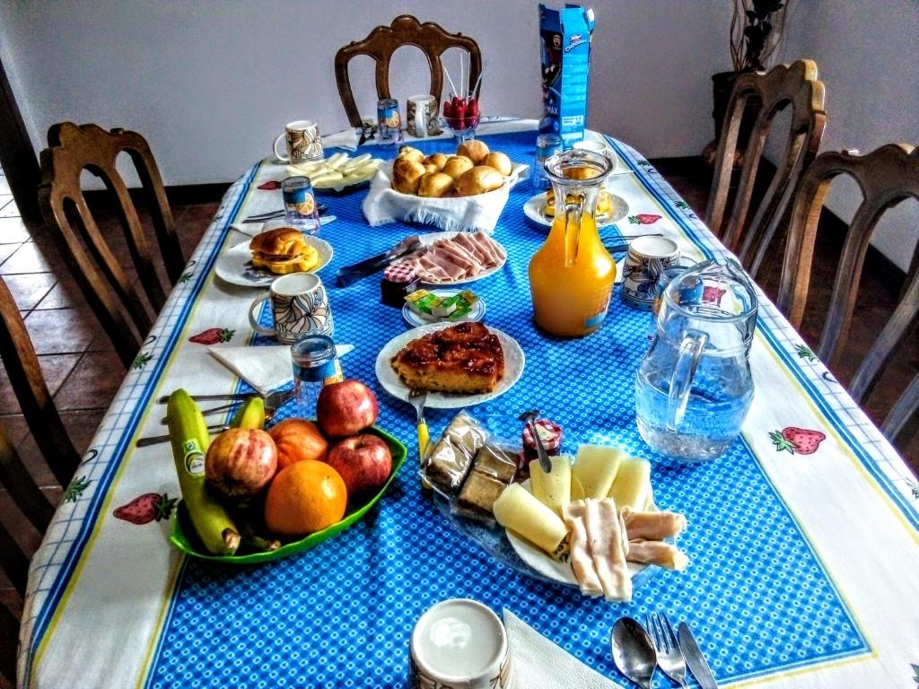 einen Tisch mit einem blauen Tischtuch mit Essen drauf in der Unterkunft Casa Vale do Rio Ovil in Baião