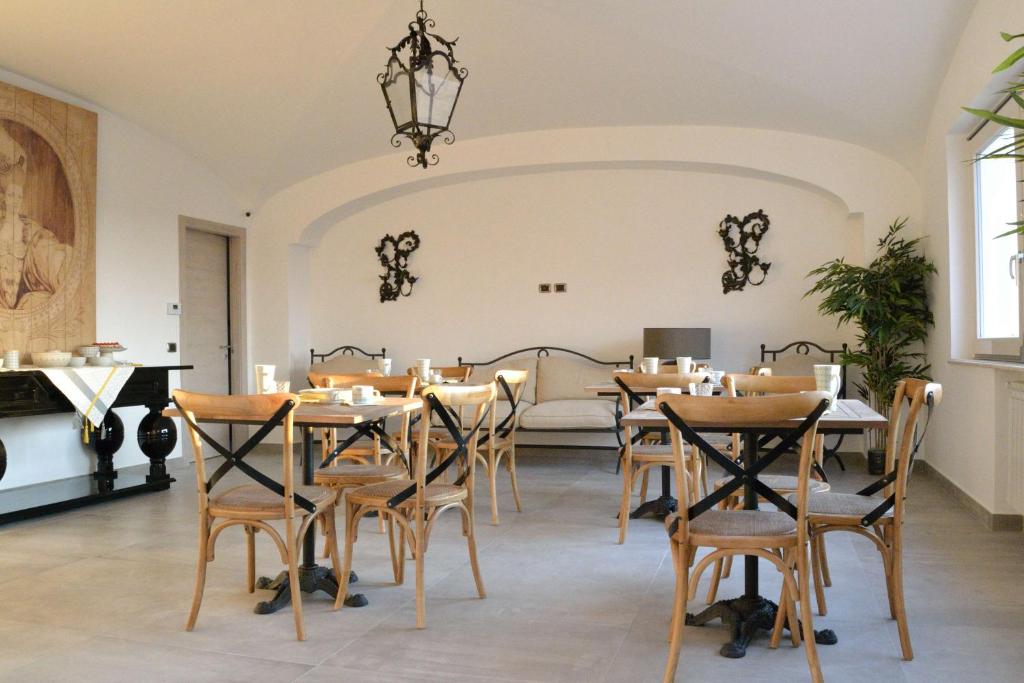 un comedor con mesas, sillas y un piano en B&B Cloud, en Santa Maria Capua Vetere