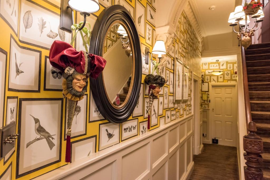 a hallway with a mirror and pictures on the walls at The Devonian in Douglas