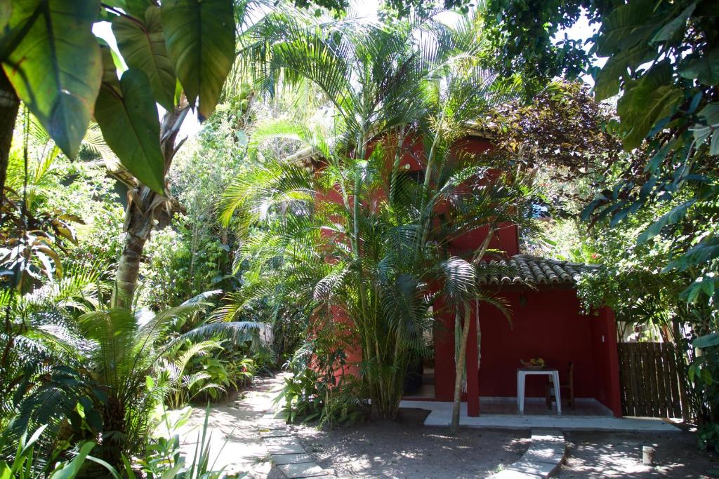 uma casa vermelha no meio de um jardim em Casa da Beatriz em Trancoso