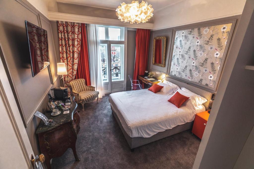 una camera d'albergo con letto e finestra di Grand Hotel Bellevue - Grand Place a Lille