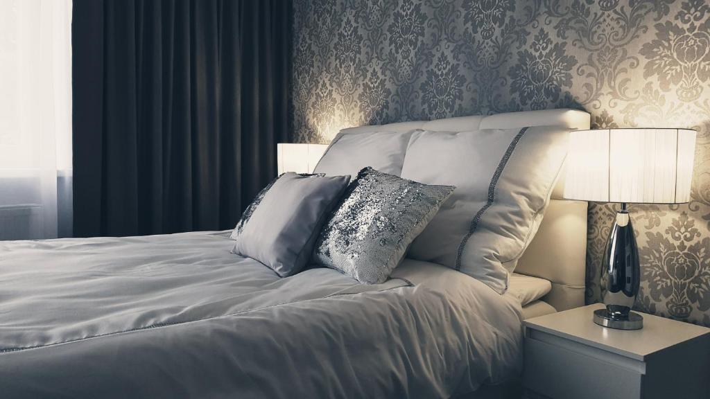 1 dormitorio con 1 cama blanca y 2 almohadas en Silver Apartaments en Piła