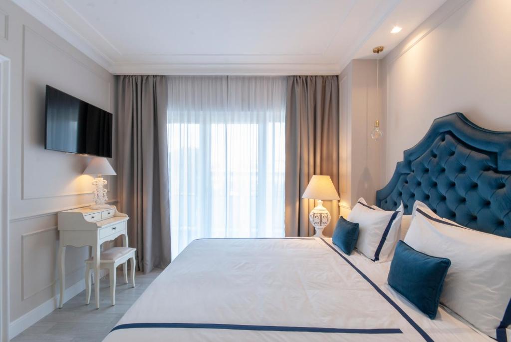 NLM Boutique Apartment في روما: غرفة نوم مع سرير كبير مع اللوح الأمامي الأزرق