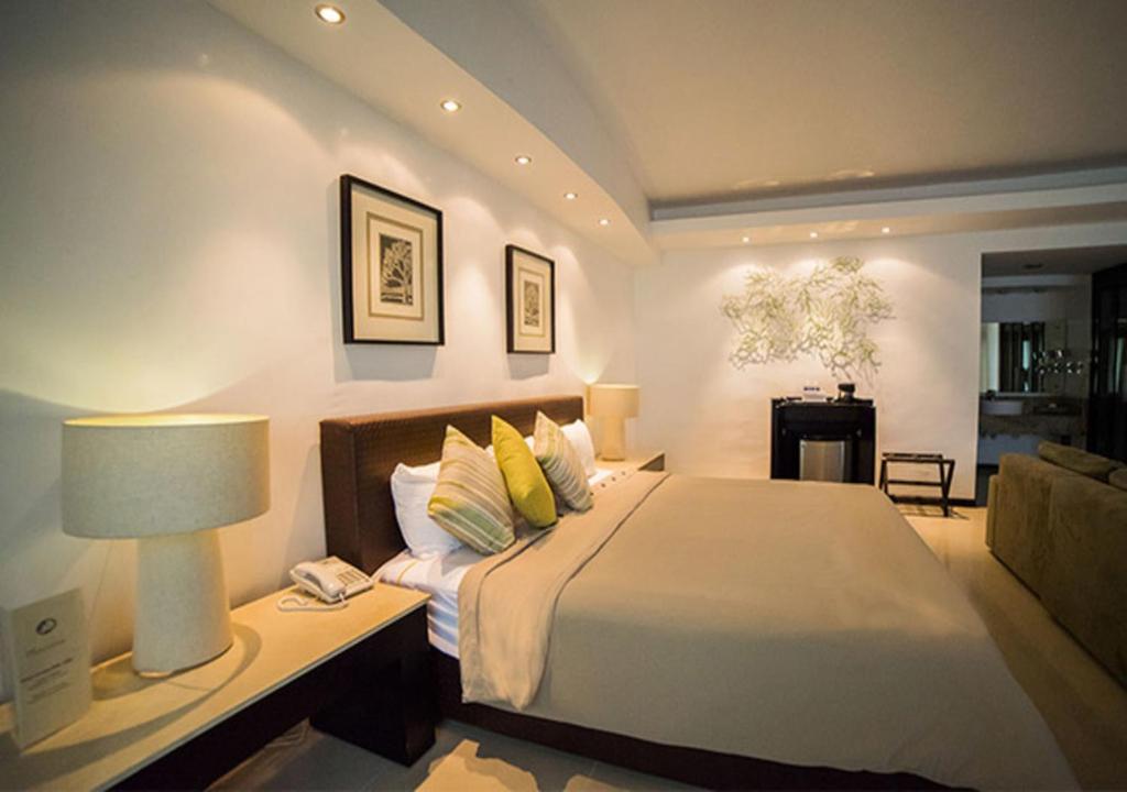 - une chambre avec un lit et une table avec une lampe dans l'établissement Hotel Grand Marlon, à Chetumal