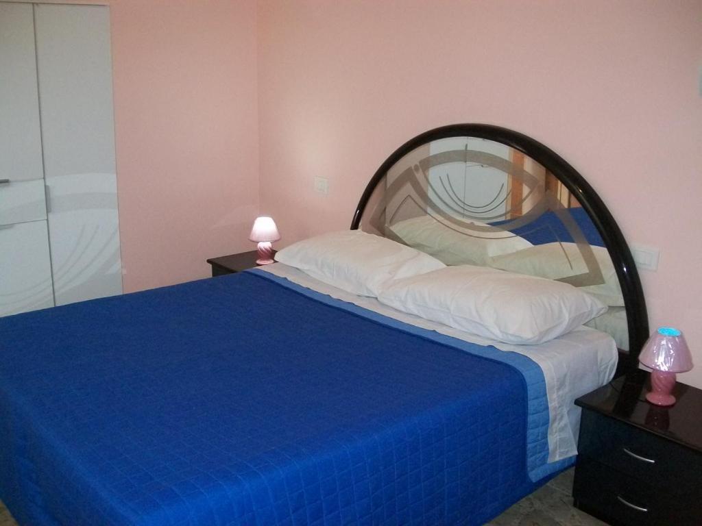 una camera da letto con un grande letto con una coperta blu di Affittacamere il girasole a Recanati
