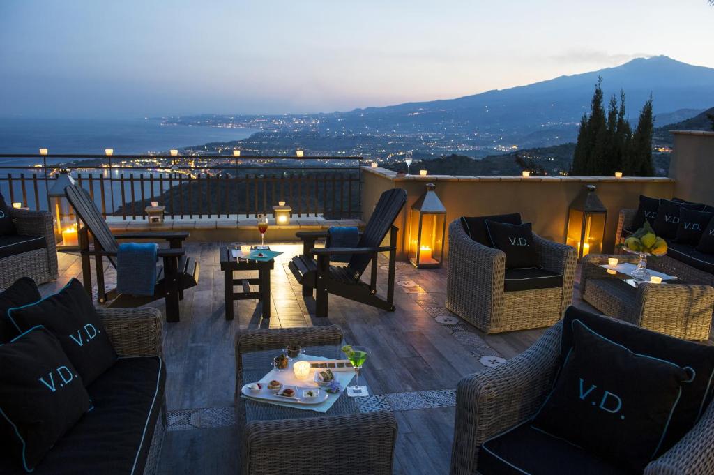 a patio with chairs and a table on a balcony at Hotel Villa Ducale in Taormina