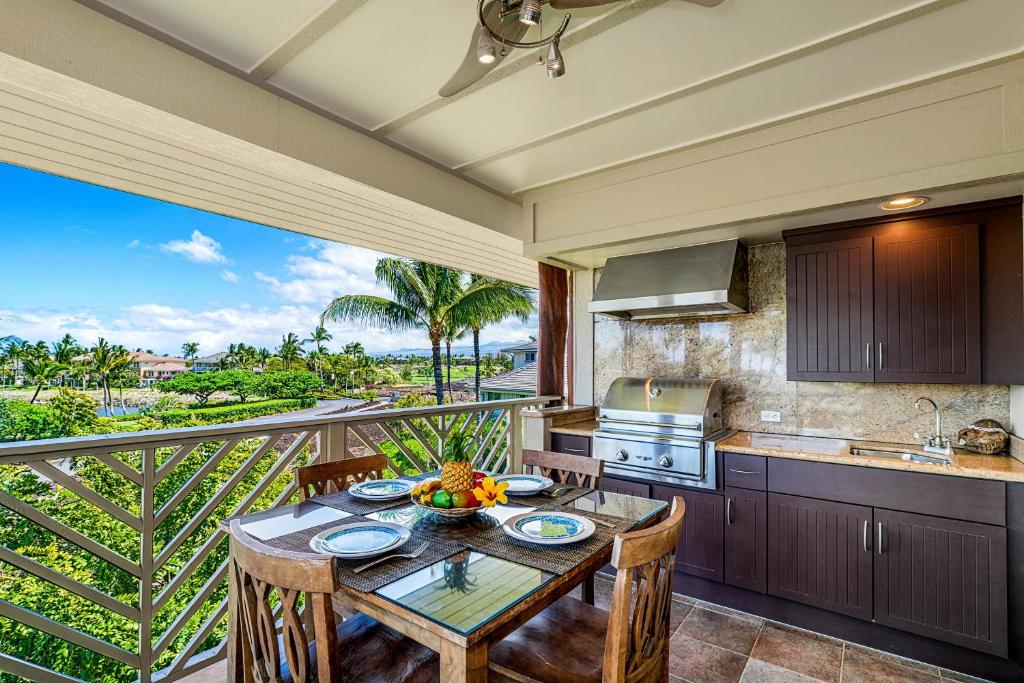 eine Küche mit einem Tisch und einem Balkon in der Unterkunft Waikoloa Beach Villas E32 in Waikoloa