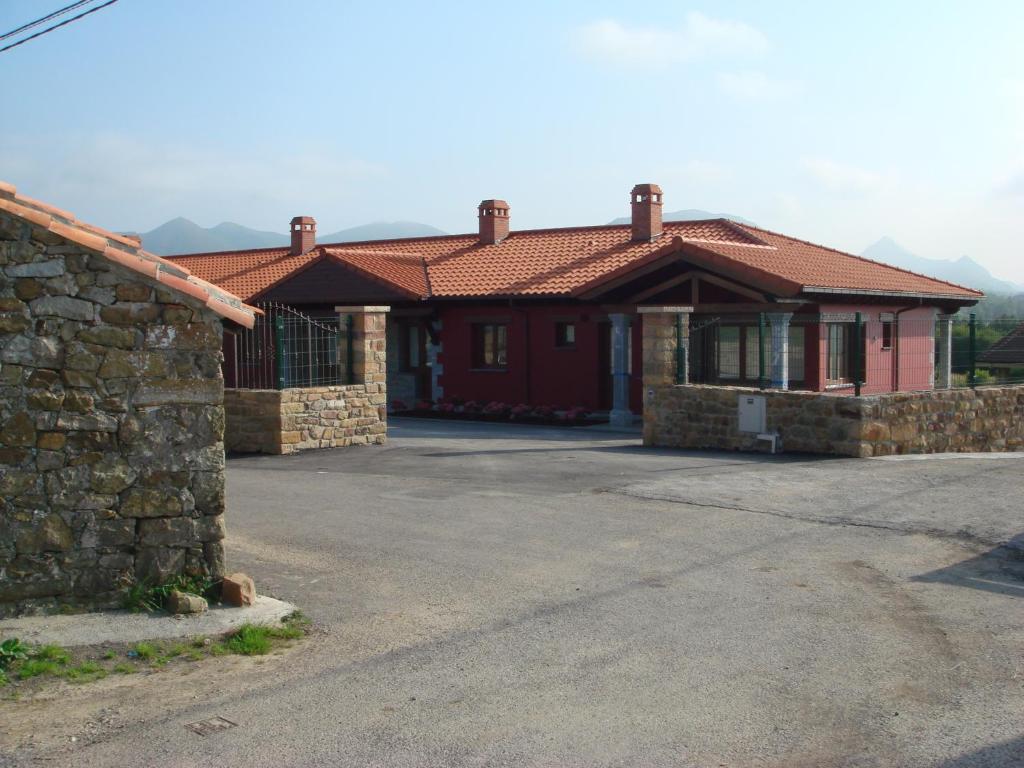 ein Haus mit einer Steinmauer neben einer Auffahrt in der Unterkunft Los Picos de Tereñes in Tereñes