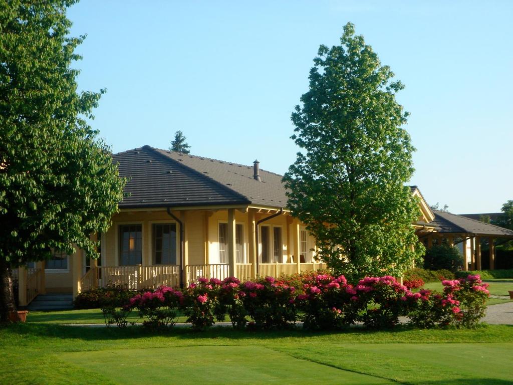 une maison avec des fleurs devant elle dans l'établissement Golf Club Cavaglià, à Cavaglià